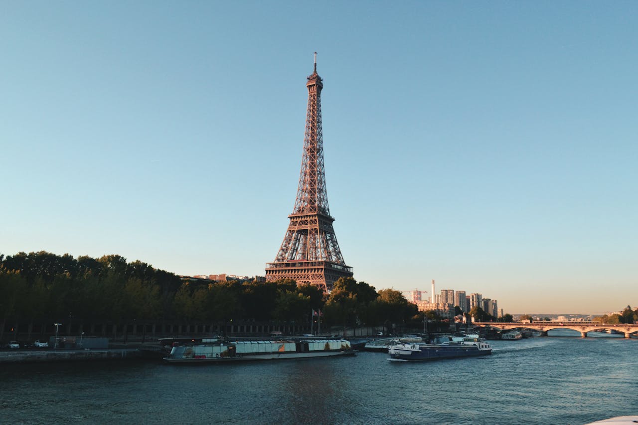 services-02 Scenic view of the Eiffel Tower and Seine River at sunset, showcasing iconic Parisian architecture.