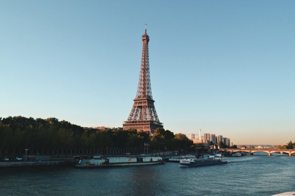 pexels-photo-2082103 Scenic view of the Eiffel Tower and Seine River at sunset, showcasing iconic Parisian architecture.
