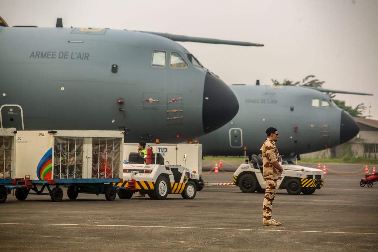 services-img Military personnel near French Air Force planes at an airfield. Cargo loading in progress.